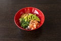 Large classic poke bowl of chopped Norwegian salmon with edamame beans,