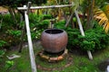 Large clay cauldron hung on wooden stick structure