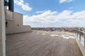 Large clean balcony with dark tiles under the blue sky