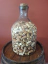 Large clear glass bottle with many cork stoppers inside, sitting .