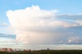 Large cloud in blue sky over city and urban park i