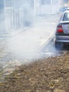 A large cloud of gray smoke from the exhaust pipe of a car in the courtyard of a residential building Royalty Free Stock Photo