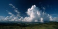 A large cloud in the sky over a grassy hillside Royalty Free Stock Photo