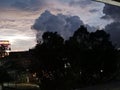 A large cluster of clouds under the evening sky. Shadows of the trees formed by the dim light of the setting sun Royalty Free Stock Photo