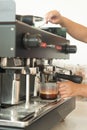 Large coffee machine and black mug while making coffee. Royalty Free Stock Photo