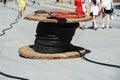 A large coil of electrical wire is lying on the footpath. Construction of infrastructural power lines