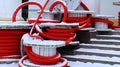 Large coils of red flexible corrugated pipe used to protect cables in electrical installations. Lots of colored polyethylene