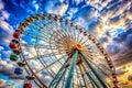 Vibrant Ferris Wheel Against a Dramatic Sunset Sky with Fluffy Clouds amusement park carnival Royalty Free Stock Photo