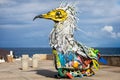 Large and colourful metal bird of prey made from pieces of junk near the sea in Los Silos, Tenerife, Spain