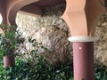 Large columns of round, carved and green tropical plants against the backdrop of a stone wall in a sea tropical resort