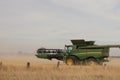 Large machinery harvesting a wheat crop on a farm in an agricultural, dry, windy and dusty farmland area near Melbourne, Royalty Free Stock Photo