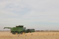 Large machinery harvesting a wheat crop on a farm in an agricultural, dry, windy and dusty farmland area near Melbourne, Royalty Free Stock Photo