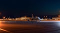 A large commercial jetliner parked on an airport at night, ready for its next flight