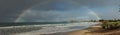 large complete full half circle rainbow stretching across the sky into the ocean at Apollo Bay, Victoria, Australia