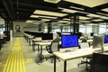 Large computer room with laptops on tables, blurred people working Royalty Free Stock Photo