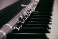 A large concert transverse flute lies on the piano keys Royalty Free Stock Photo