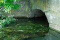 A large concrete pipe for diverting the river under the highway. Leaky dirty water from large concrete pipes. Dirty sewage from