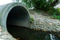 A large concrete pipe for diverting the river under the highway. Leaky dirty water from large concrete pipes. Dirty sewage from