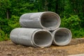 large concrete sewer pipes up on the ground cement stack gray