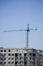 Large construction site cranes working on a building complex with clear blue sky