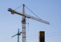 Large construction site cranes working on a building complex with clear blue sky