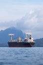 Large container cargo ship sailing in raining weather.