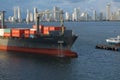 A large Container ship being gently pushed to a dock at the Cartagena Harbor