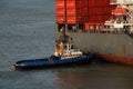 A large Container ship being gently pushed to a dock at the Cartagena Harbor