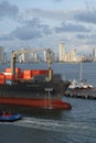 A large Container ship being gently pushed to a dock at the Cartagena Harbor