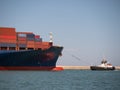 Large Container Ship Towed into Port by a Small Tugboat Royalty Free Stock Photo