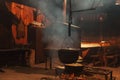 Large cooking pots are prepared using firewood.Metal boilers over a fire in a house with smoke