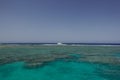 large coral reef with turquoise water and a single boat with blue sky Royalty Free Stock Photo