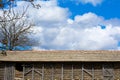 A large corncrib is full of ripe ears of corn against a blue sky and beautiful fluffy clouds. Royalty Free Stock Photo