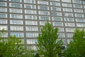 large corporate building with young trees on the foreground. Trees try to balance and compensate large space filled with concrete Royalty Free Stock Photo