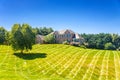 Large country brick house and summer landscape with a perfect lawn. Blue sky and white clouds Royalty Free Stock Photo