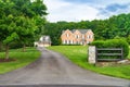 Large, country, brick two-story for large family home with detached garage, landscaping and huge green lawn. Landscape on a summer Royalty Free Stock Photo