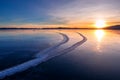 Large cracks in the clear smooth blue ice of Lake Baikal at sunset. Siberia Russia Royalty Free Stock Photo