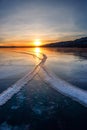 Large cracks in the clear smooth blue ice of Lake Baikal at sunset. Siberia Russia Royalty Free Stock Photo