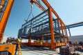 A large crane is carefully positioning a building into place at a construction site, Benefits of prefabrication in construction Royalty Free Stock Photo
