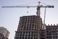 A large crane in front of a tall building Royalty Free Stock Photo