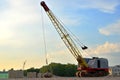 Large crawler crane or dragline excavator with a heavy metal wrecking ball on a steel cable.