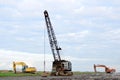 Large crawler crane or dragline excavator with a heavy metal wrecking ball on a steel cable. Wrecking ball