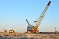 Large crawler crane or dragline excavator with a heavy metal wrecking ball on a steel cable. Wrecking balls at construction sites