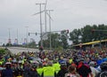 A large crowd of bicycle riders waiting on a public road