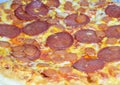 Large crust pizza with mozzarella, salami, pepperoni and cheddar cheese Royalty Free Stock Photo