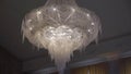 Large crystal chandelier from ceiling with electric lamps. Luxurious interior. Royalty Free Stock Photo