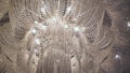 Large crystal chandelier from ceiling with electric lamps. Luxurious interior. Royalty Free Stock Photo