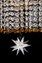 Large crystal chandelier close-up in baroque style isolated on black background.