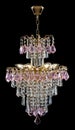 Large crystal chandelier, pink crystals isolated on black background. Royalty Free Stock Photo