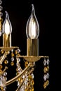 Large crystal close-up chandelier with candles isolated on black background. Royalty Free Stock Photo